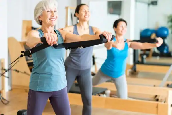 Toning Arms After 60: Empowering Womens Fitness Through Effective Weight Training 2 older woman doing weight training Livingston and resistance in the gym to tone upper arms